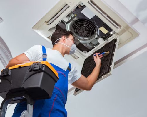 worker-repairing-ceiling-air-conditioning-unit_85869-7023